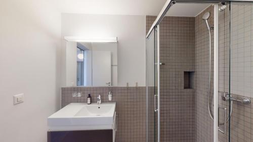 a bathroom with a sink and a shower with a mirror at Family Apartment Sot Lantsch-Lenzerheide for 6 persons in Lenz