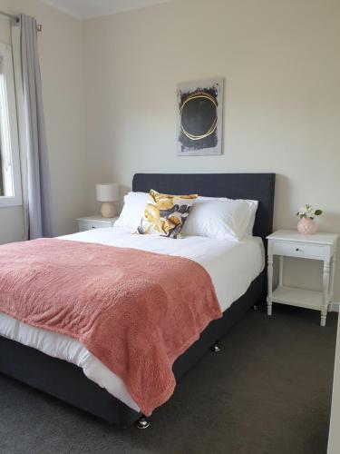 1 dormitorio con 1 cama grande con manta roja en Heinlen on Bridges Street, en Mount Gambier