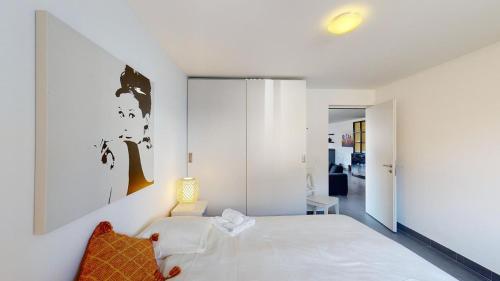 una camera con un letto bianco e una parete bianca di Family Apartment Sot Lantsch-Lenzerheide for 6 persons a Lenz
