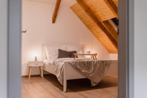 een slaapkamer met een wit bed en een houten vloer bij Romantický LOFT parking u hlavního nádraží in Olomouc