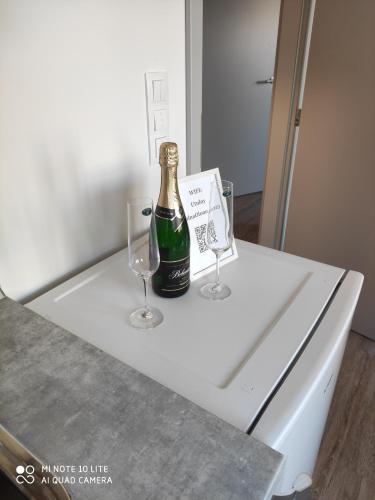 a bottle of champagne and two wine glasses on a counter at Romantický LOFT parking u hlavního nádraží in Olomouc