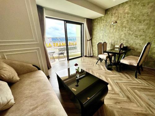 ニャチャンにあるGold Coast Luxury Apartment Nha Trangのリビングルーム(ソファ、テーブル付)