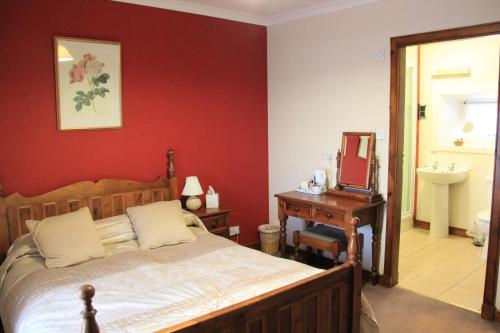 a bedroom with a bed and a mirror and a sink at Craignure Inn in Craignure