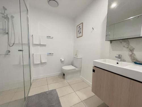 y baño con aseo, lavabo y ducha. en Lovely 2 Beds Apt with City View at South Brisbane, en Brisbane