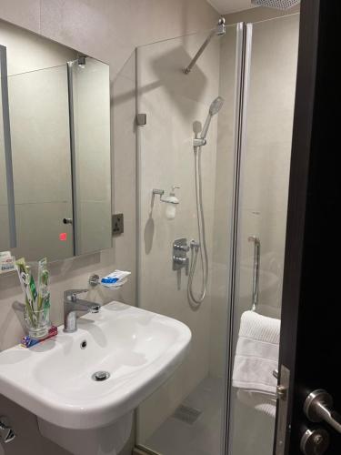 a bathroom with a white sink and a shower at Aeon Tower 2627 in Davao City