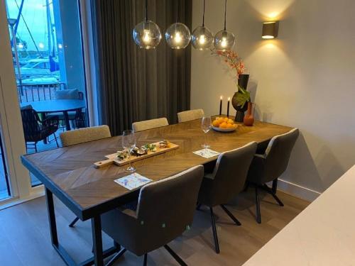 a dining room with a wooden table and chairs at Luxe appartement in haven Marina Kamperland - 2 badkamers in Kamperland