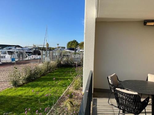 a patio with a table and chairs on a balcony at Luxe appartement in haven Marina Kamperland - 2 badkamers in Kamperland