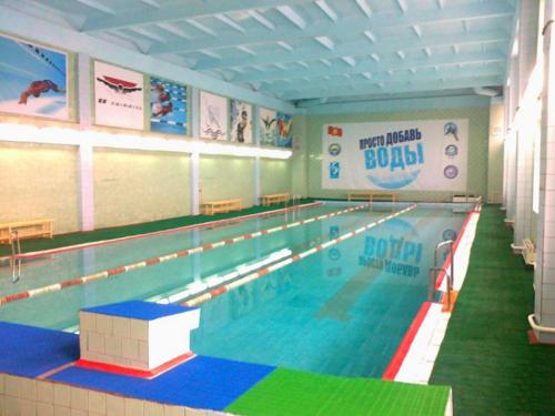 a large swimming pool in a large room at Apartment na VEFe in Bishkek