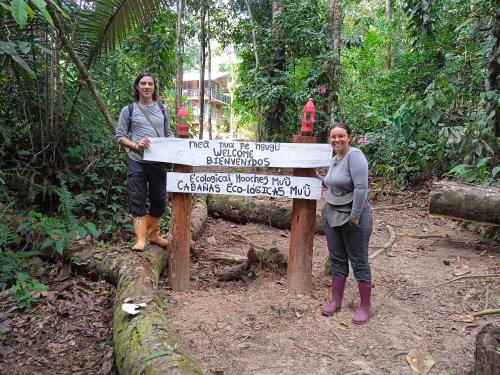 two women standing next to a sign in the forest at Cabañas eco lógicas mu'ü in Loreto Mocagua
