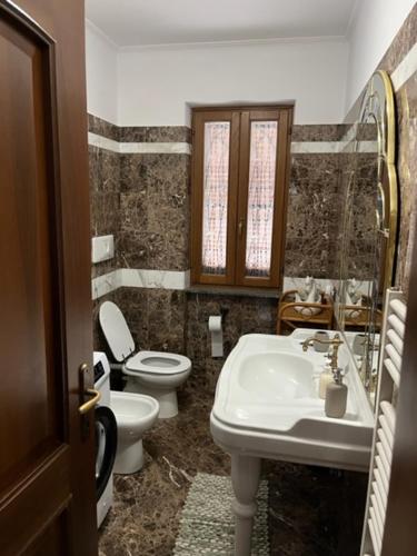 a bathroom with a toilet and a sink at Villa Ines in Ardea