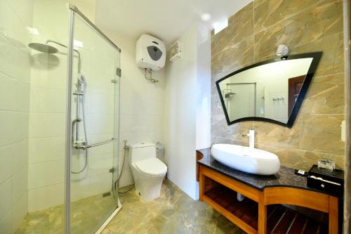 a bathroom with a toilet and a sink and a shower at Sapa Symphony Hotel in Sa Pa