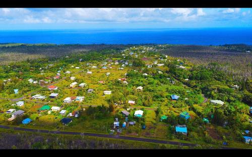 an aerial view of a village with houses and the ocean at Puna Pod in Pahoa