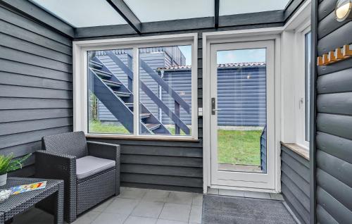 a screened in porch with a chair and windows at Hytteby – Hanstholm Camping – Thy Feriepark in Hanstholm