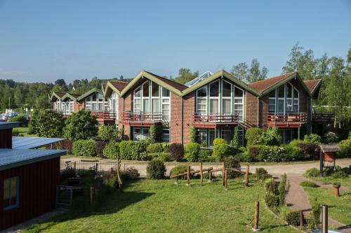 a large brick house with a yard in front of it at An der Metow-Ferienpark Hotel in Plau am See