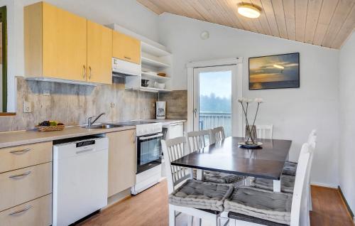 a kitchen with a table and a dining room at Hytteby – Hanstholm Camping – Thy Feriepark in Hanstholm