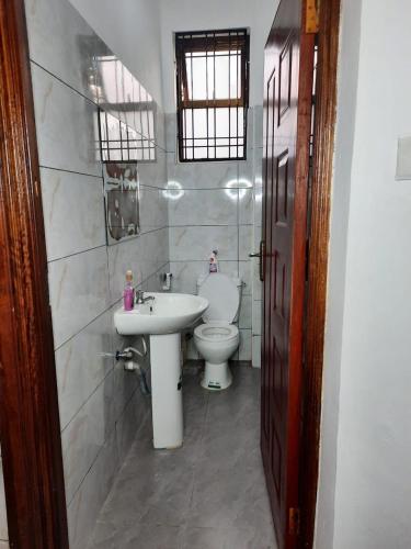 a bathroom with a sink and a toilet at Lux Suites Carina Casey Apartments Bamburi in Bamburi