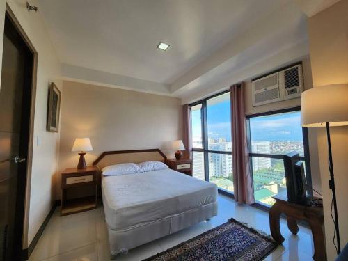 a bedroom with a bed and a large window at Casa Antonio at Viceroy McKinley Hill in Manila