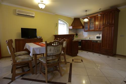 a kitchen with a table and chairs and a tv at Club Unicum in Hévíz