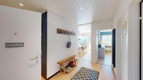 a hallway with white walls and a wooden bench at Ski in-Ski out Apartment Luscheina-Lenzerheide in Valbella