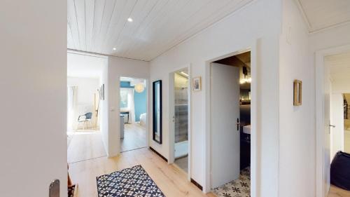 sala de estar con paredes blancas y pasillo en Ski in-Ski out Apartment Luscheina-Lenzerheide, en Valbella
