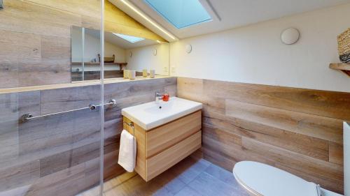 a bathroom with a sink and a glass shower at Ski in-Ski out Apartment Luscheina-Lenzerheide in Valbella