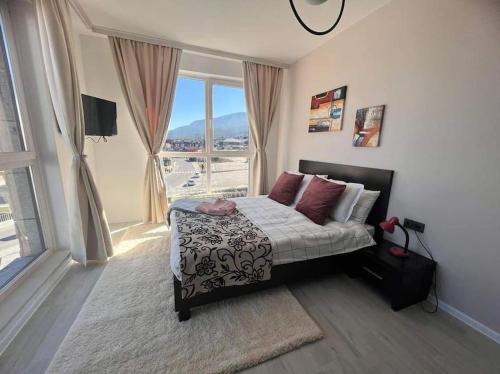 a bedroom with a bed and a large window at The Tower - Lovely apartment @ Bansko Royal Towers in Bansko