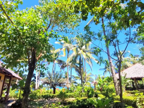 a view of the beach through the trees at Sulu Sunset Beach Resort in Nauhang