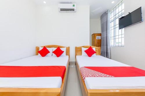 Duas camas com almofadas vermelhas num quarto em Hải Phát Hotel em Thôn Trà Long