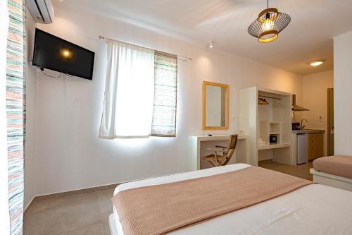 Habitación blanca con cama y ventana en Alisea Resort, en Kimolos