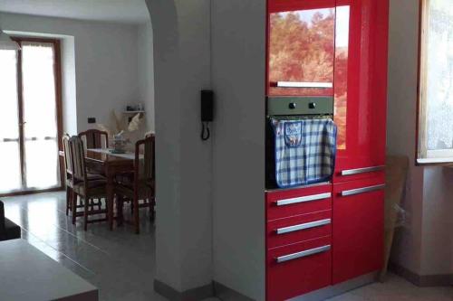 a red cabinet in a kitchen with a dining room at Casa Valentina in Colombara