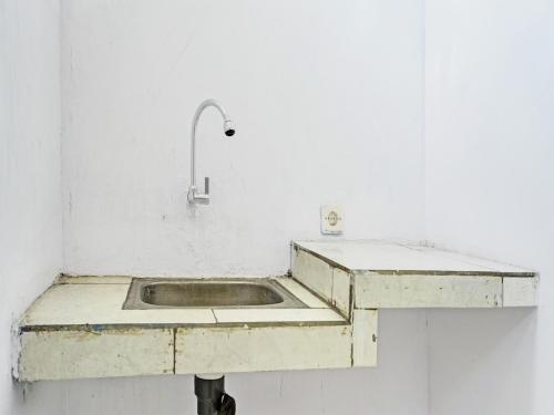 a concrete sink in a white room with a faucet at OYO 91796 Guest House Ghalta Syariah in Karawang