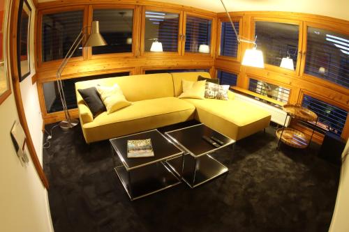 a living room with a yellow couch and a table at The Birdy Mountains Luxury Lodge 2, 230qm,Sauna,Entertainment in Schlitz