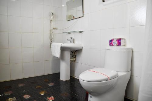 a bathroom with a white toilet and a sink at Way Young House in Jiufen