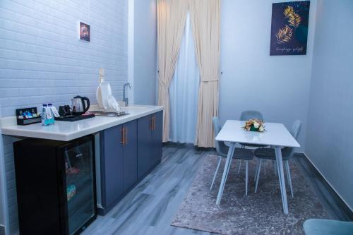 a kitchen with a sink and a table with two chairs at فندق روند in Hafr Al Baten