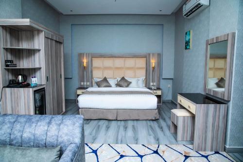 a bedroom with a large bed and a couch at فندق روند in Hafr Al Baten
