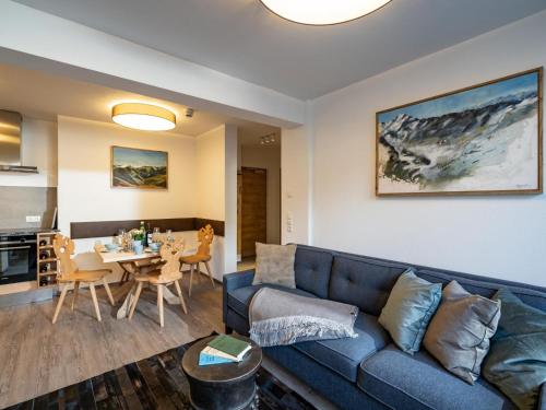 un soggiorno con divano blu e tavolo di Alpine Homes - Hopfgarten a Hopfgarten im Brixental