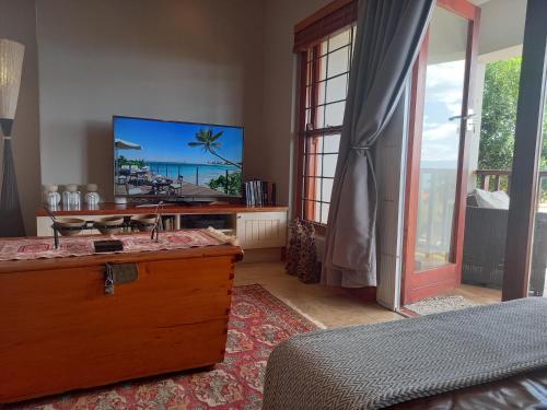 a bedroom with a tv and a bed and a bed sidx sidx sidx at Barmarine Luxury Holiday Home in Mossel Bay