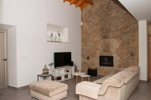 a living room with a couch and a stone wall at Beautiful cozy cottage near Nazaré, Leiria&Batalha in Juncal