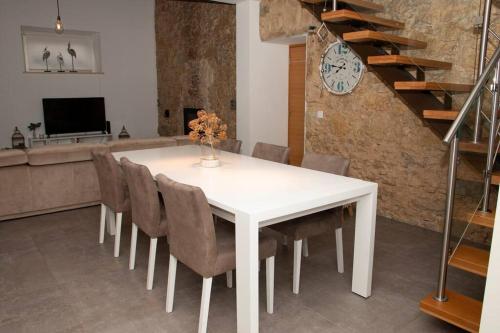 a dining room with a white table and chairs at Beautiful cozy cottage near Nazaré, Leiria&Batalha in Juncal