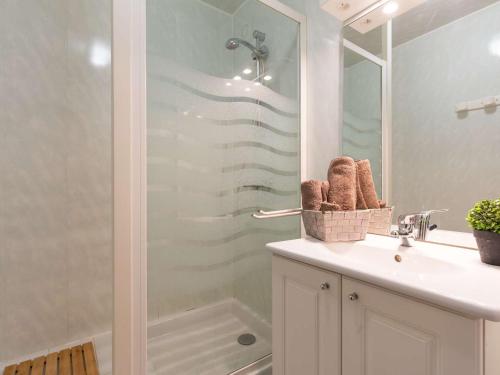 a bathroom with a shower and a sink and a mirror at Appartement Saint-Lary-Soulan, 3 pièces, 7 personnes - FR-1-296-296 in Saint-Lary-Soulan