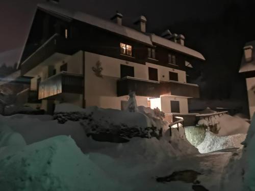 a building in the snow at night at La casa del Cucù al Ravascletto, 900mt from cable car in Zovello