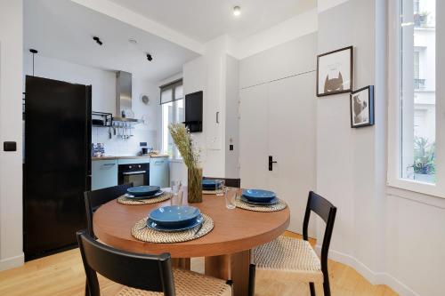 une cuisine et une salle à manger avec une table et des chaises en bois dans l'établissement Bastille - Cosy design 1BR / 4P apartment, à Paris