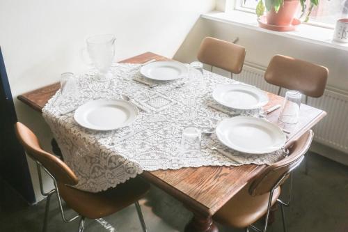 a wooden table with white plates on it at Villa apartment Hafnarfjordur - Ideal for Aurora in Hafnarfjördur
