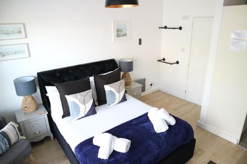 a bedroom with a large bed with towels on it at 12a Mault-Ley Studio in St Ives