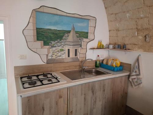 una cocina con fregadero y un espejo sobre un mostrador en La Nicchia, en Ragusa
