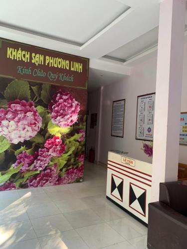 una sala de espera con flores rosas en la pared en Phuong Linh Hotel, en Bảo Lạc