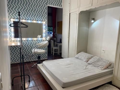 Dormitorio pequeño con cama y pared en Quarto Camarim, en Río de Janeiro