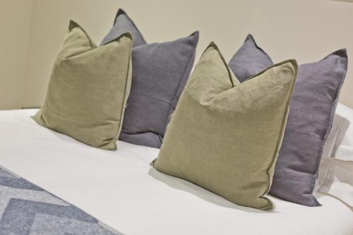 a group of pillows sitting on top of a bed at Sandgate Chapel - Self Check In Apartments in Penrith