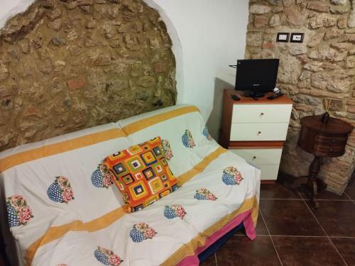 a bedroom with a bed and a stone wall at La taverna sotto la torre in Massa Marittima