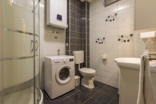 ein Badezimmer mit einer Waschmaschine und einem WC in der Unterkunft Apartman Vlatka - Novi Vinodolski in Novi Vinodolski